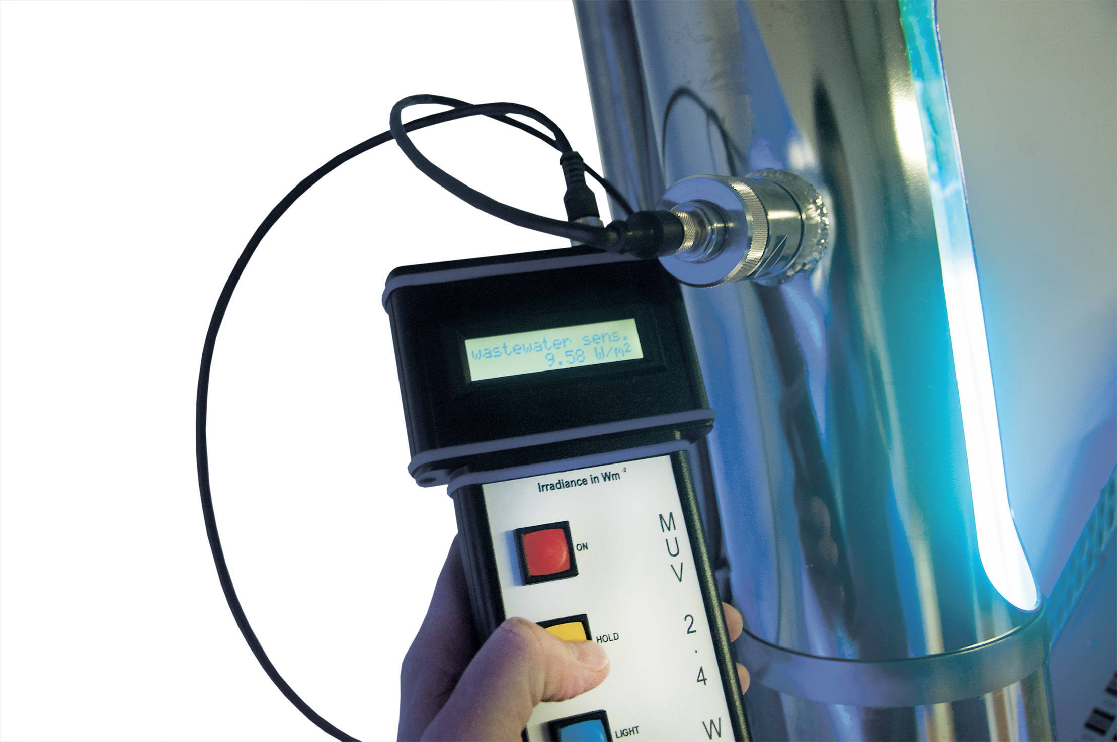 Person holding MUV2.4 / KUV2.4 UV measurement device checking water plant sensor; device displays critical measurement.